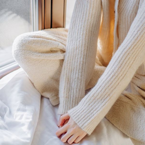 Person meditating peacefully by a window with soft morning light.